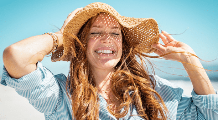 Summer Self-care. Woman outside in the sun wearing a sun hat.