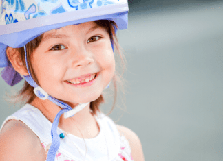 Young girl wearing a purple bike helmet