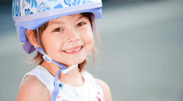 Young girl wearing a purple bike helmet