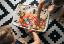 Kids filling up laundry basket with water balloons