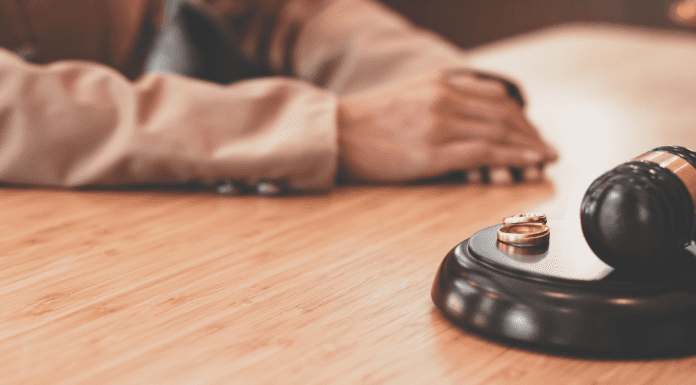 Wedding rings placed near a gavel in a courtroom