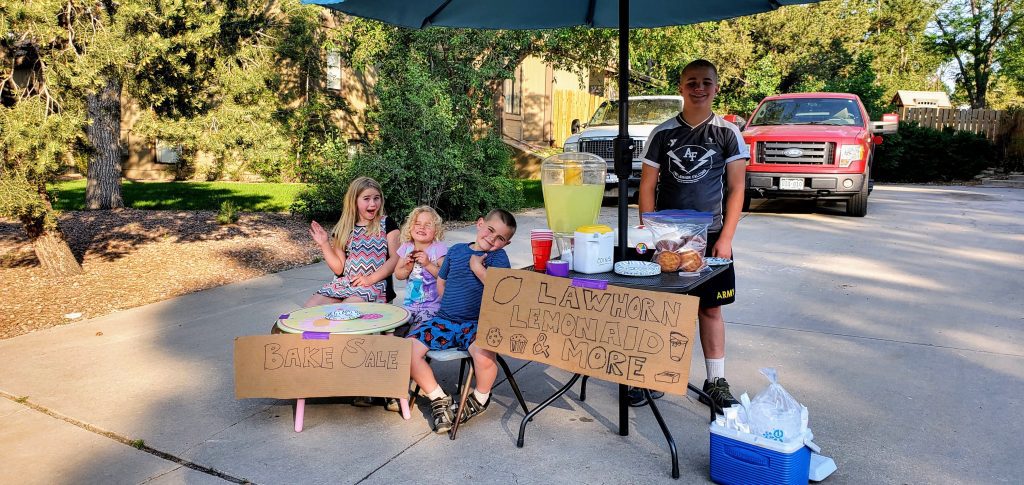 Kids holding lemonade and bake sale