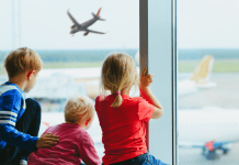 3 kids at airport watching the planes