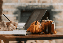 Woman writing in a calendar at a table decorated with pumpkins