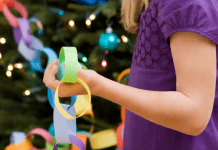 Girl with a paper chain near a Christmas Tree