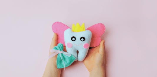 Child's hands holding a tooth fairy pillow