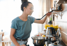 woman standing over a pot while cooking.