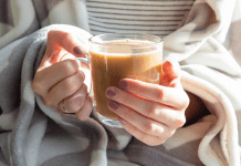 close up of a woman holding a cup of coffee